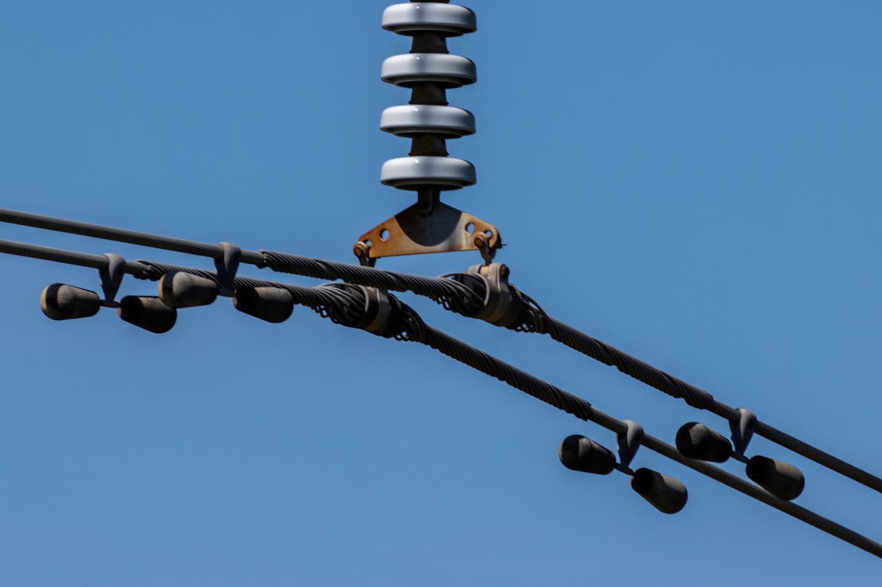 who-we-are Detailed view of overhead power lines with blue sky background. Ideal for energy themes.